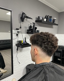 Corte de pelo moderno para hombre con degradado fade y diseño de líneas hecho en la barbería by Juanjo Barber en Ayamonte.