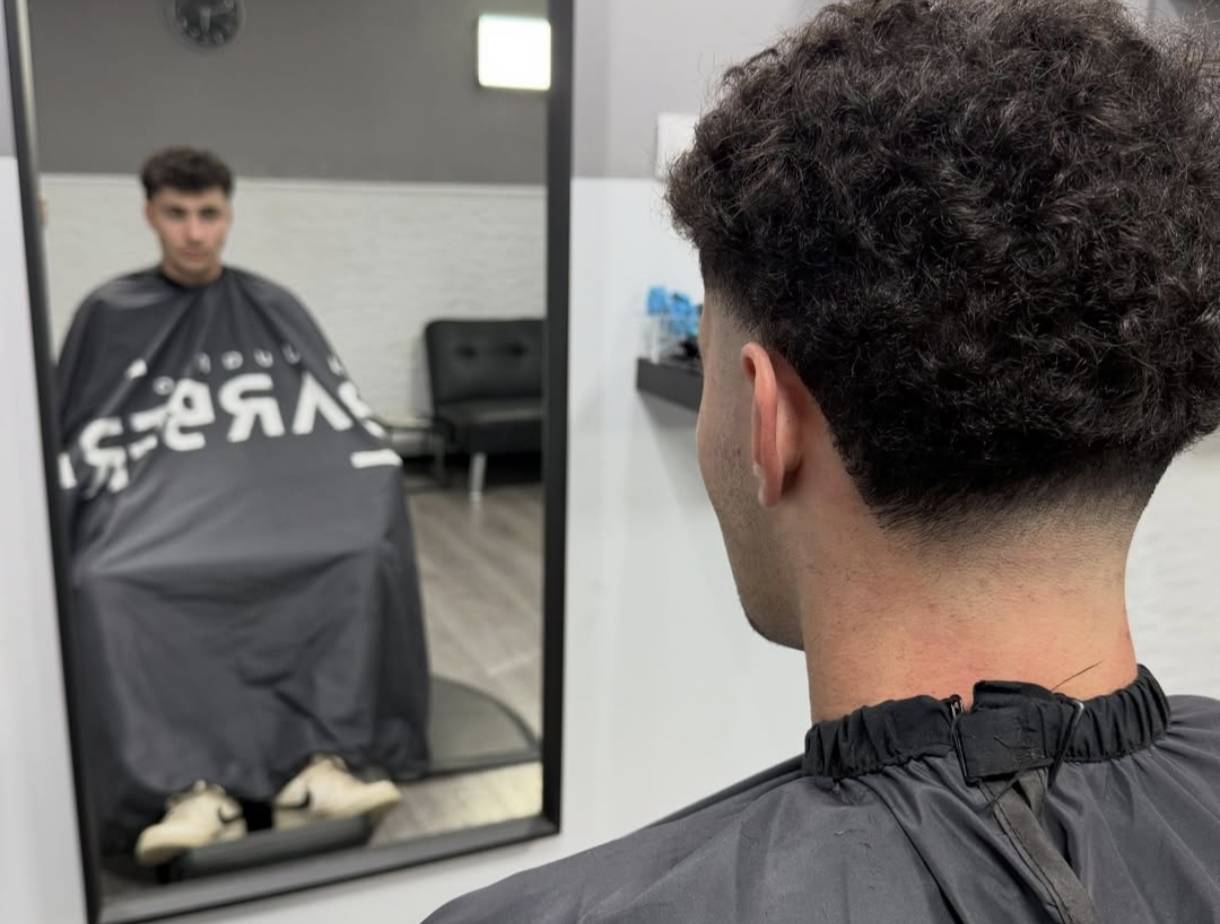 Primer plano de un corte de pelo masculino con un degradado bajo (low fade) y textura, realizado por by Juanjo Barber.