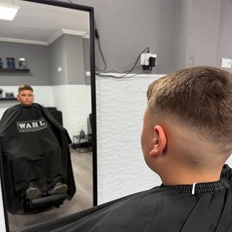Cliente mostrando su nuevo look: un corte con degradado y peinado con tupé, realizado en peluquería by Juanjo Barber.